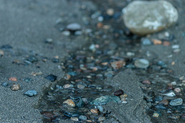 close up of pebbles in a trickle of water
