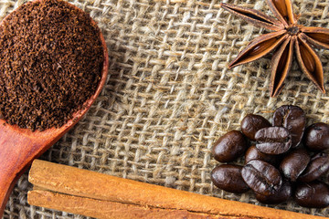 Freshly hot brewed coffee. Coffee beans, cinnamon and anise stars on a dark wooden background
