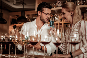 Positive delighted young people tasting alcohol drinks