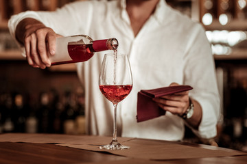 Close up of bartender that dropping wine