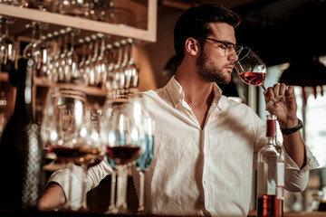 Young bearded man smelling aroma of pink drink - Powered by Adobe