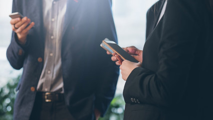 Online daily routine. Cropped shot of male and female colleagues distracted with smartphones.