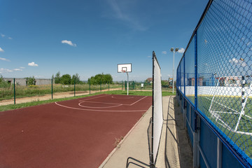Basketball structure in an outdoor playground surrounded by trees in a park