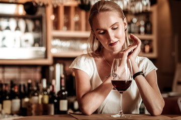 Relaxed young woman looking at bocal of wine