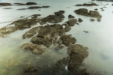 Long Exposure Photography of Waves on stone beach waters edge abstract sea background.Thailand.