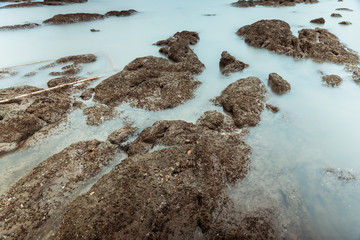 Long Exposure Photography of Waves on stone beach waters edge abstract sea background.Thailand.
