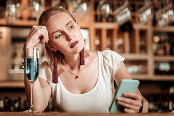 Dreamy blonde female being deep in thoughts