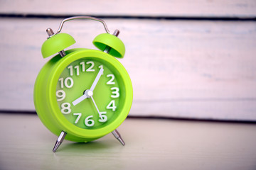 Retro alarm clock on white wooden background. Wake up in the mornig. Copy space for text. Best...