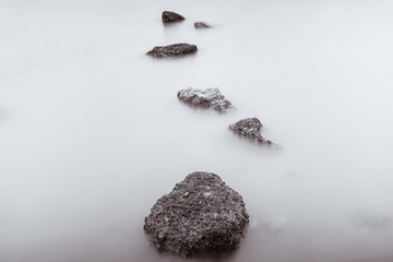 Photo Black and White of Long Exposure Photography Waves on stone beach waters edge abstract sea background.Thailand.