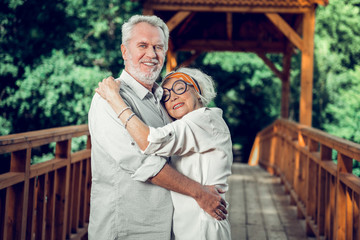 Face portrait of female hugging the spouse in years outdoors