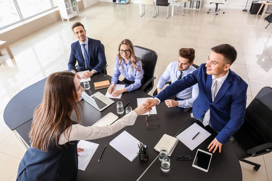 Human resources manager shaking hands with applicant after successful interview