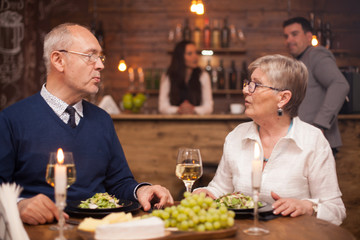 Older sister telling her little brother what she's been up to lately while having dinner in a cozy restaurant