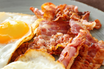 Tasty fried eggs and bacon on plate, closeup