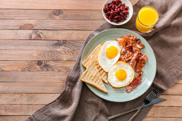Tasty English breakfast  with fried eggs, bacon, beans and toasts on table