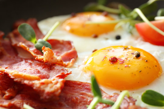 Tasty fried eggs and bacon, closeup