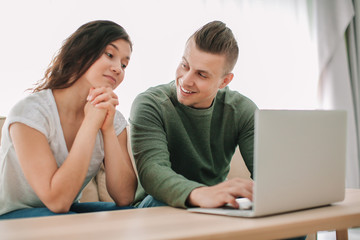 Fototapeta premium Adorable loving couple watching movie at home