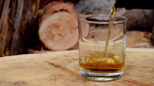 Canadian Club 1858 whiskey mixed with coke ice splash with wood background, 1920x1080 25fps