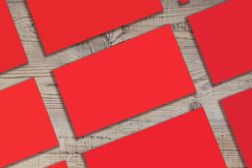 Mockup of horizontal red business cards stacks arranged in rows at wooden background.