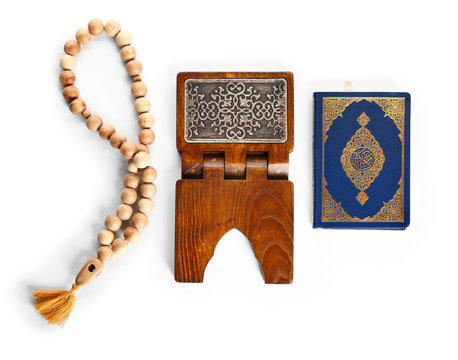 Muslim beads, rehal and Koran on white background