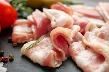 Fresh raw bacon on slate plate, closeup