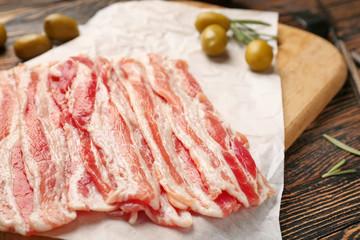 Fresh raw bacon on wooden board, closeup