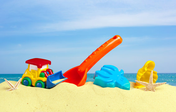 colorful toys for child sandboxes against the beach sand background