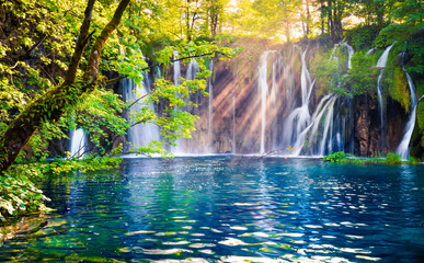Last sunlight lights up the pure water waterfall on Plitvice National Park. Colorful spring scene...