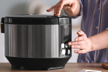 Woman using modern multi cooker in kitchen, closeup