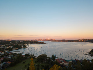 Aerial view of Sydney Harbour under the sunrise light.