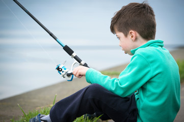 child boy holds fishing rod