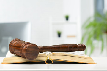 Wooden judge gavel on table, front close-up view