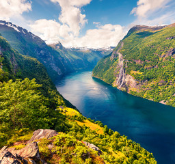 Splendid summer scene of Sunnylvsfjorden fjord, Geiranger village location, western Norway. Aerial view of famous Seven Sisters waterfalls. Beauty of nature concept background.