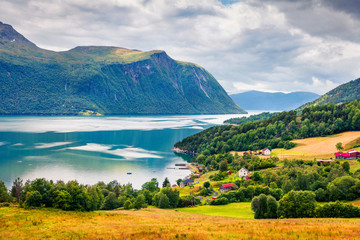 Naklejka na ściany i meble Typical countryside Norwegian landscape. Summy summer morning in Norway, Europe. Beauty of nature concept background. Artistic style post processed photo.