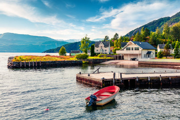 Picturesque summer view of typical Norwegian village on the shore of fjord. Traveling concept...