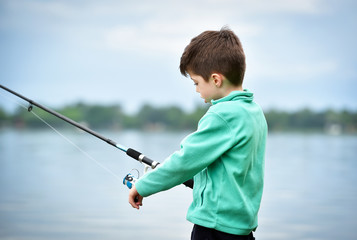 child boy holds fishing rod