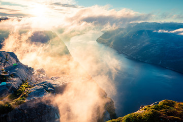 Foggy morning view of popular Norwegian attraction Preikestolen. Great summer scene of the Lysefjorden fjord, located in the Ryfylke area in southwestern Norway. Beauty of nature concept background.