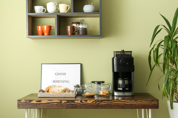 Modern coffee machine and sweets on kitchen table