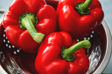 Ripe red peppers in colander, closeup