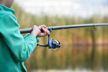 child boy holds fishing rod