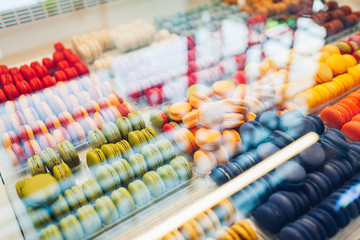 Assortment of colorful macaroons on cafe showcase. Variety of macaron flavours. Sweet almond cakes in store.