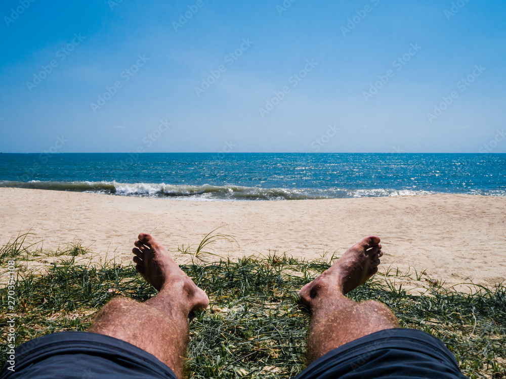Wall mural sunbathing man on the sandy beach