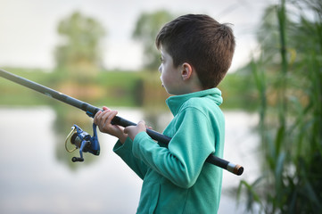 child boy holds fishing rod