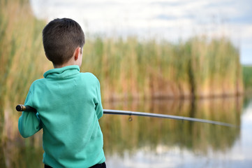 child boy holds fishing rod