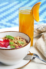Delicious organic smoothie bowl and a glass of fresh squeezed orange juice, healthy raw vegan meal