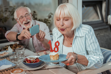 Positive delighted mature people celebrating birthday in cafe