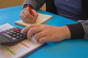 man hand using calculator, accounting concept. Man hands with pencil, notebook and Calculator