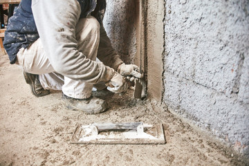 Real construction worker making a wall inside the new house.