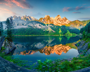 Impressive summer morning on the Vorderer Gosausee lake. Colorful sunrise in Austrian Alps, Salzkammergut resort area in the Gosau Valley in Upper Austria, Europe. Beauty of nature concept background.