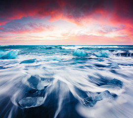 Blocks of ice washed by the waves on Jokulsarlon beach. Dramatic summer sunrise in Vatnajokull National Park, southeast Iceland, Europe. Beauty of nature concept background.
