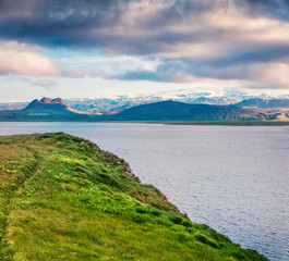 Typical Icelandic landscape with volcanic mountains and Atlantic ocean coast. Sunny summer morning in the west coast of Iceland, Europe. Beauty of nature concept background.